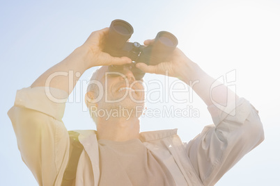 Happy hiker looking through binoculars