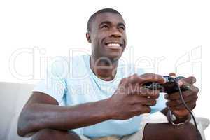 Smiling man sitting on couch playing video games