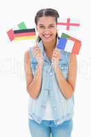 Pretty brunette holding various european flags