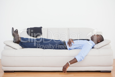 Tired businessman sleeping on the sofa