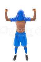 Excited football player in blue cheering with jersey over head