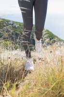 Fit woman jogging on mountain trail