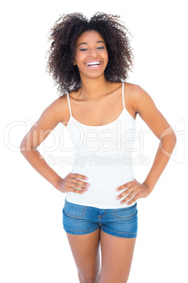 Pretty girl in white top and denim hot pants smiling at camera