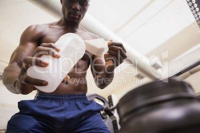 Body builder scooping up protein powder