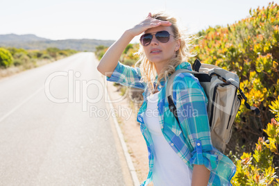 Attractive blonde hitch hiking on rural road