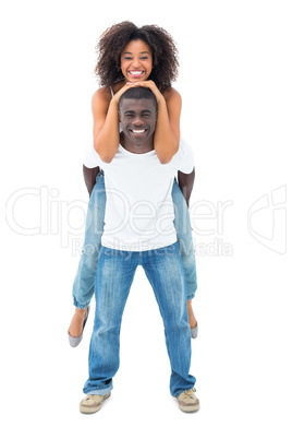 Casual man giving his smiling girlfriend a piggy back