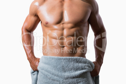 Mid section of a shirtless muscular man wrapped in towel