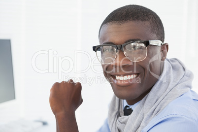 Hipster businessman smiling at his desk