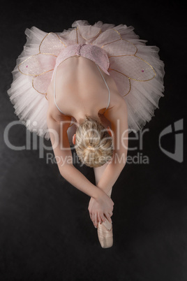 Graceful ballerina bending forward in pink tutu