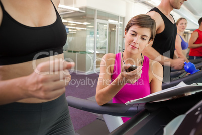 Trainer timing her client on the treadmill