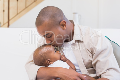 Happy father spending time with baby on the couch