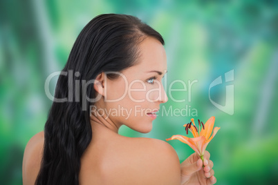 Beautiful nude brunette smelling lily
