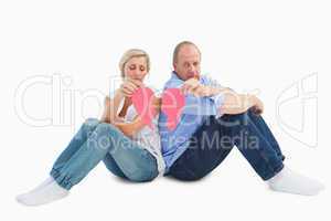 Sad mature couple holding a broken heart
