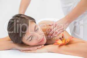 Attractive woman receiving shoulder massage at spa center