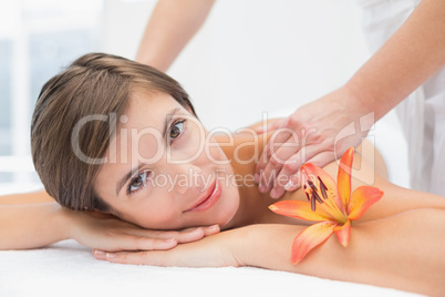 Attractive woman receiving shoulder massage at spa center