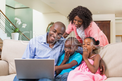 Happy family relaxing on the couch using laptop Happy family relaxing on the couch using laptop