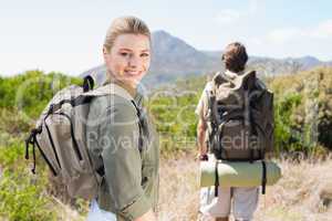Attractive hiking couple walking on mountain trail woman smiling