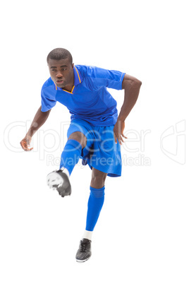 Football player in blue kicking Football player in blue kicking