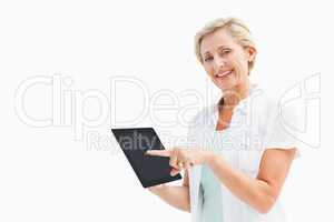 Happy mature woman pointing to tablet pc