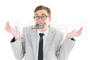 Geeky shrugging businessman biting calculator