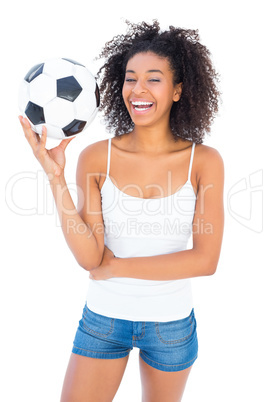 Pretty girl holding football and smiling at camera