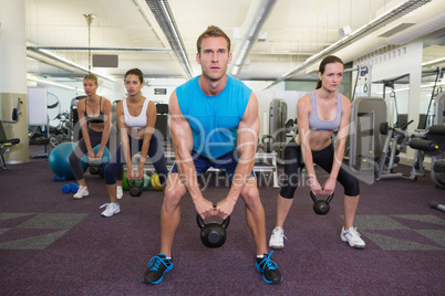 Muscular instructor leading kettlebell class