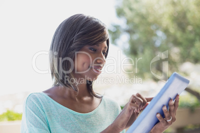 Pretty woman sitting outside using tablet pc