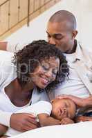 Adorable baby boy sleeping while being watched by parents