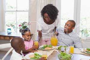 Mother serving juice to her family at lunch