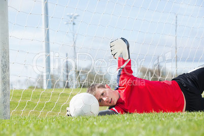 Goalkeeper in red making a save
