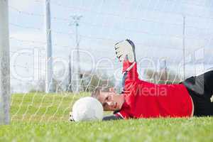 Goalkeeper in red making a save