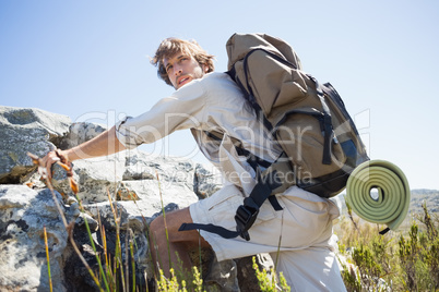 Handsome hiker hiking through rough terrain