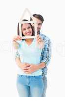 Happy young couple with house shape