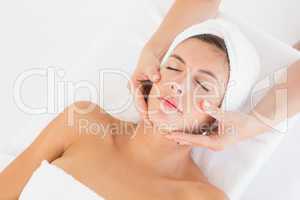 Attractive woman receiving facial massage at spa center