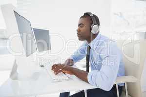 Focused businessman working at his desk listening to music
