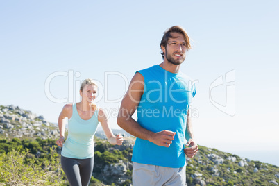 Fit couple jogging through countryside