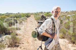 Handsome hiker smiling at camera in the countryside