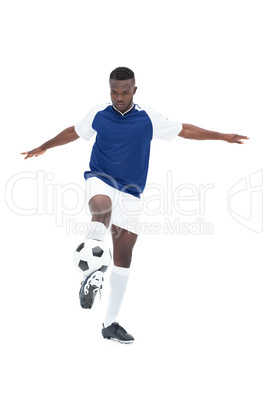 Football player in blue jersey controlling ball