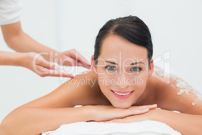 Peaceful brunette getting a salt scrub beauty treatment