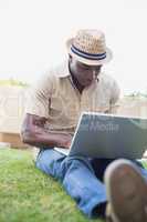 Handsome man relaxing in his garden using laptop
