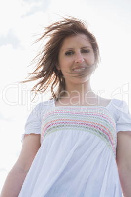 Smiling young woman against sky