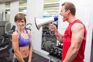 Personal trainer shouting at client through megaphone