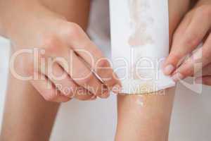 Woman waxing her legs herself