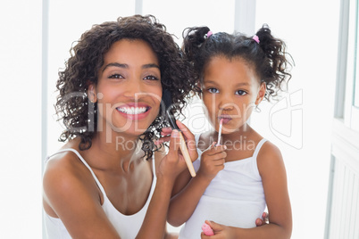 Pretty mother teaching her daughter about makeup