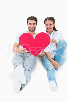 Cute couple sitting holding red heart