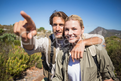 Happy hiking couple walking on mountain terrain