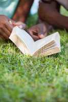 Young couple reading book on the grass