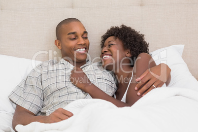 Happy couple lying in bed together