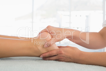 Woman receiving leg massage at spa center