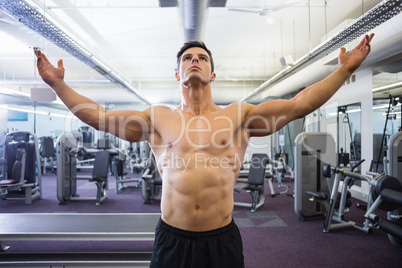 Shirtless bodybuilder standing in gym